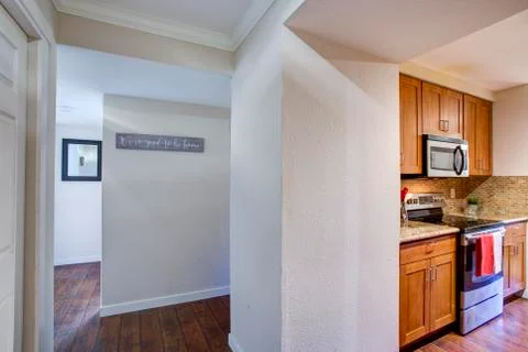 View of Small galley kitchen design from the white hallway in Bellevue apartm Stock Photos