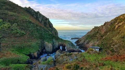 View of the small house on the seascape between the mountain slopes Stock Photos