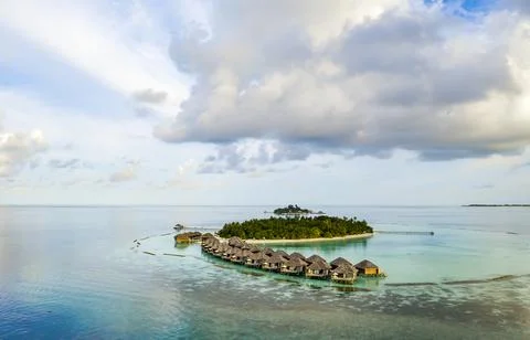 A view of a small Maldives island with a string of bungalows Stock Photos