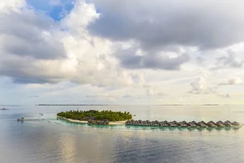 A view of a small Maldives island with a string of bungalows Stock Photos