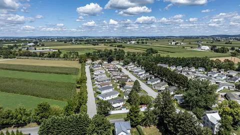 View of a Small Residential Area Surrounded by Fields and Farms During Daytim Stock Photos