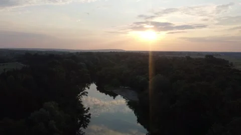 View of a small river among the trees at sunrise from a bird's eye view. Video stock 245112524