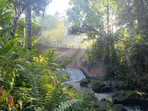View of the small river and artificial waterfall under the bridge. Stock Photos