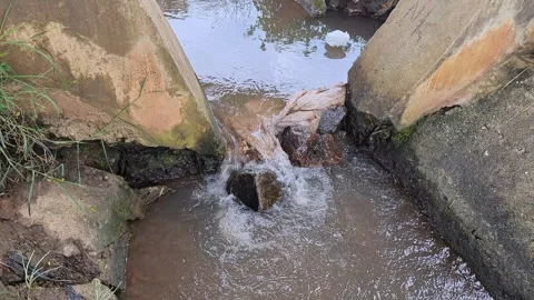 View of Small stream flowing through concrete irrigation channel in rural are Stock Footage 336044022