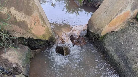 View of Small stream flowing through concrete irrigation channel in rural are Vídeos de archivo 336044324