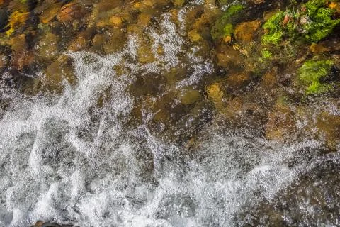 View of small waterfall on river with detail of water foam, rocks Stock Photos
