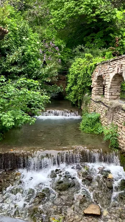 View of a small waterfall in rocks among trees in Balchik, Bulgaria. 4k Stock Footage 342794927