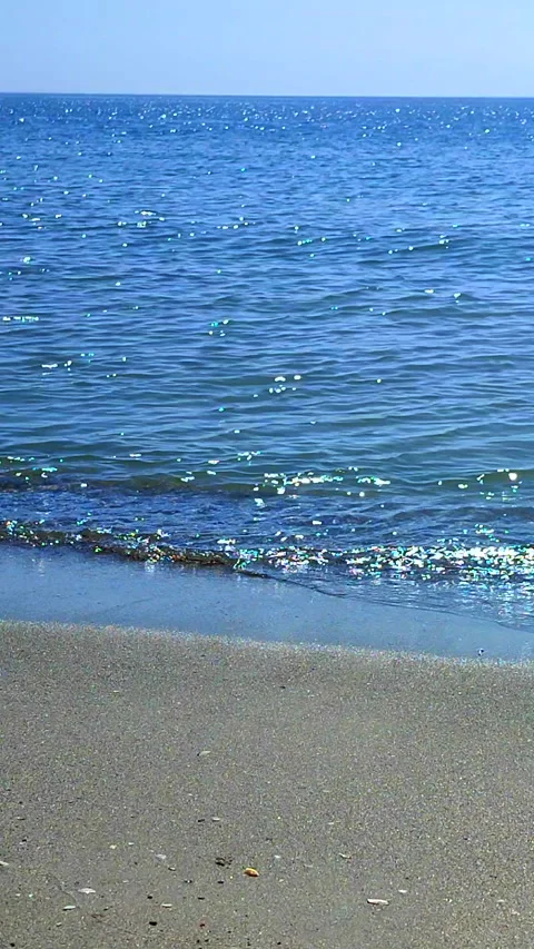 View small waves blue sea blue sky skyline sandy beach sunny summer day Vertical Stock Footage 294216475
