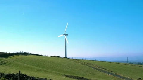 View of small wind turbine generating electricity on a local farm in south wales Stock Footage 150318477