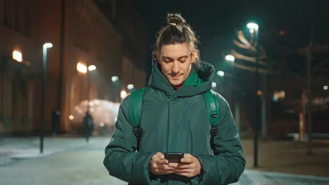 View of a smiling guy communicating on social networks using a mobile phone. Stock Footage 231690791