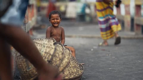 View of a smiling young boy sitting near woven baskets, Bangladesh. Video stock 335584030