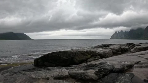 View of smooth granite shore and Okshornan peaks across ocean in Senja Norway Vidéo 342059430