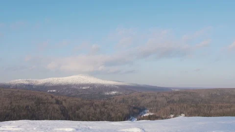 View of the snow-capped mountain top and clouds in the blue sky Stock Footage 128571771