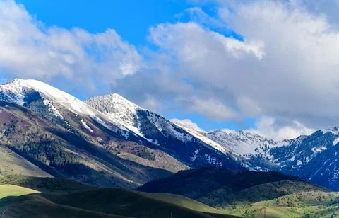 View of the snow-capped mountains in the clouds near the lake Gren Titon, USA 스톡 사진