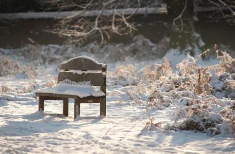 A view of a snow covered empty bench in the grounds of the Elizabethan Wollat Stock Photos