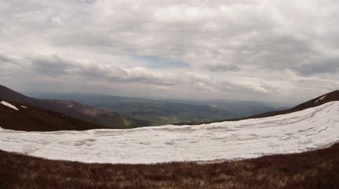 View From Snow-Covered Mountain Top on Valley Below Under Heavy Clouds Stock Footage 63963327