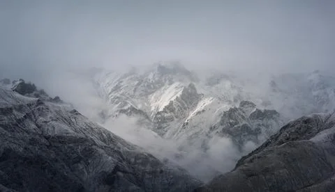 View of snow mountain surrounded by clouds with morning fog Stock Photos