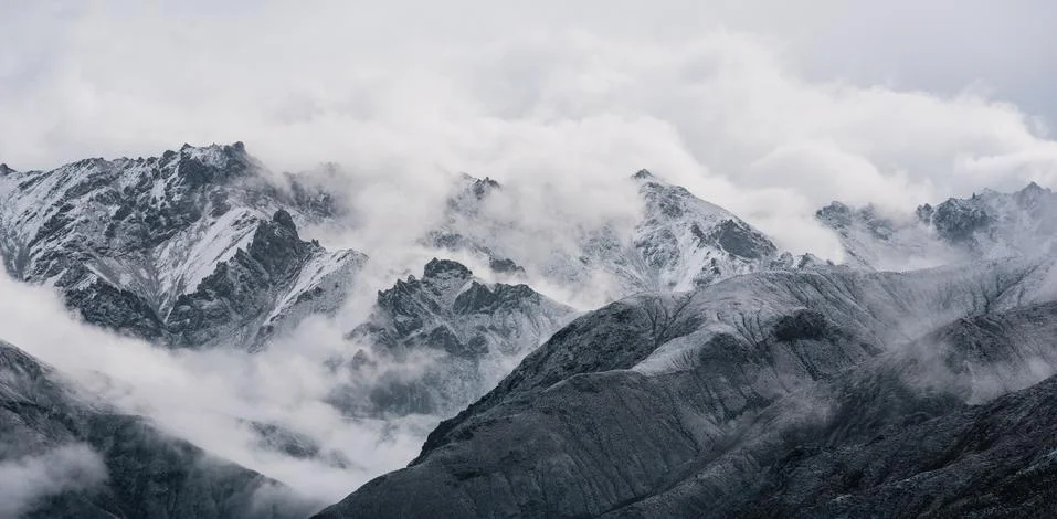 View of snow mountain surrounded by clouds with morning fog Stock Photos