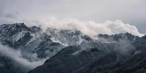 View of snow mountain surrounded by clouds with morning fog Foto stock