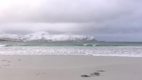 View of a snowy beach with mountains in the background in Lofoten, Norway Stock Footage 136774062