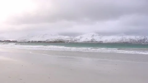 View of a snowy beach with mountains in the background in Lofoten, Norway Stock Footage 136774263