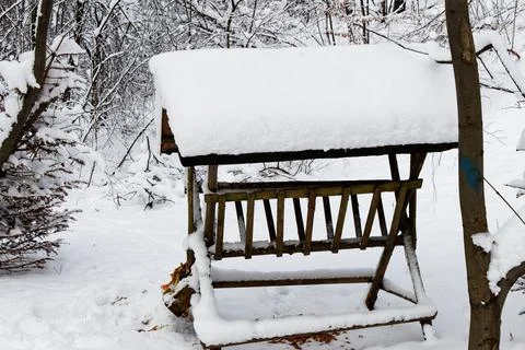 View on a snowy empty feeder for wild animals in forest in winter Stock Photos
