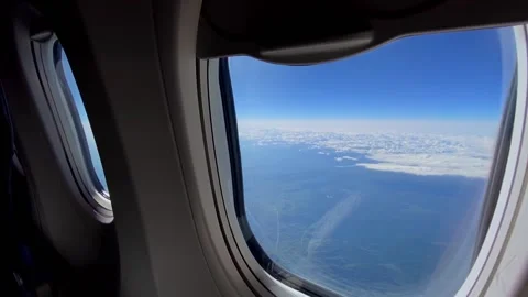 View of snowy mountains shrouded in clouds from an airplane window Stock Footage 194446034