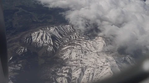 View of snowy mountains through airplane window Stock Footage 88786306