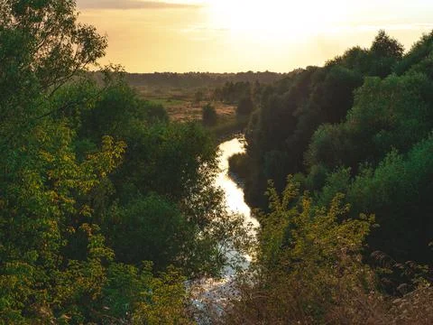 The view on the solitude river,trees and field in some rural area in the suns Stock Photos