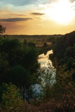 The view on the solitude river,trees and field in some rural area in the suns Stock Photos