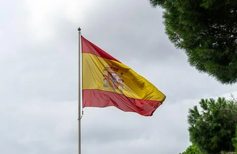 View of the Spanish Flag Flapping in the Wind attached to Metal Post Stock Photos