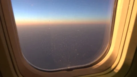 View of spectacular sunset orange light from airplane window aircraft travel day Stock Footage 81980127
