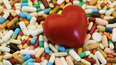 View of spinning heart among various medication pills Stock Footage 97054358