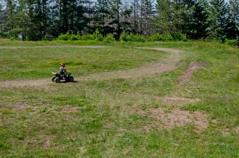 View of springtime glade, dreen forest and child drive small motor Stock Photos