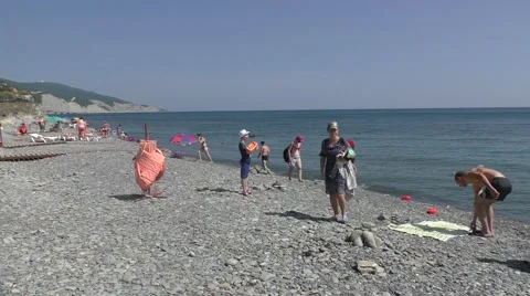 View of Standing People in Pebble Beach Near Sea and White Cliff on Background Stock Footage 65675114