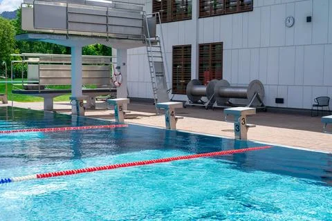 View of the starting blocks and diving towers at an outdoor swimming pool Stock Photos