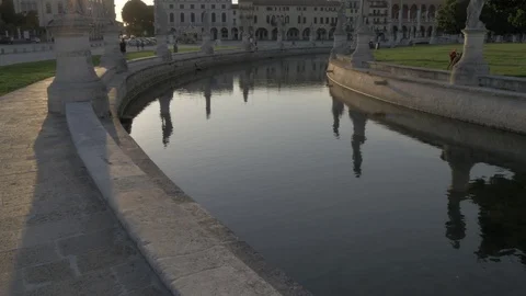View of statues in Prato della Valle rejecting in water at sunset, Padua, Stock Footage 91951356