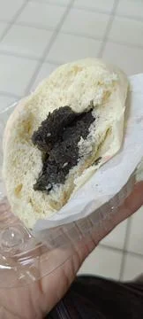 View of a steamed bun filled with mashed green beans that has been bitten Stock Photos