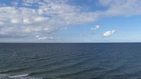View from steep coast to ocean, cloudy sky - some grasses in the foreground Stock Footage 139221376
