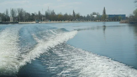 View from a stern of floating boat in the river. Waves and splashes on the water Видео 105882537