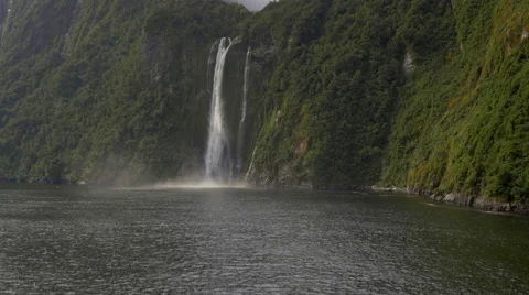 View of Stirling Falls flowing through mountains at Milford Sound, South Island, Stock Footage 51478785