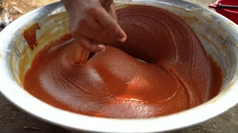 View of stirring thick brown paste in a bowl, Bangladesh. Stock Footage 335765730