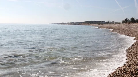 View of a stone beach with a clean transparent water and relaxing waves Stock Footage 125561963
