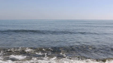 View of a stone beach with a clean transparent water and relaxing waves Stock Footage 125562358