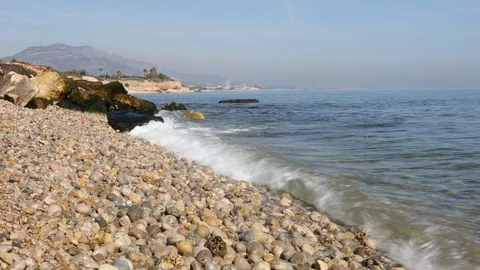 View of a stone beach with a clean transparent water and relaxing waves Stock Footage 125562620