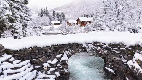 View of a stone bridge over a snowy river in Valldal, Norway. Video stock 343683845