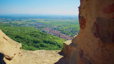 View from stone cave opening overlooking village and plains near Ribeauville 스톡 동영상 327629639