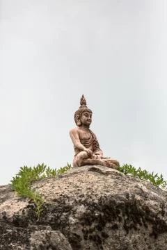 View of stone statue, buddha on big rock Stock Photos