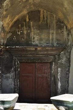 View of a stone wall and a large wooden door. Stock Photos