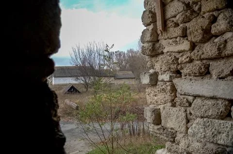 View from a stone wall opening towards a rural village Stock Photos